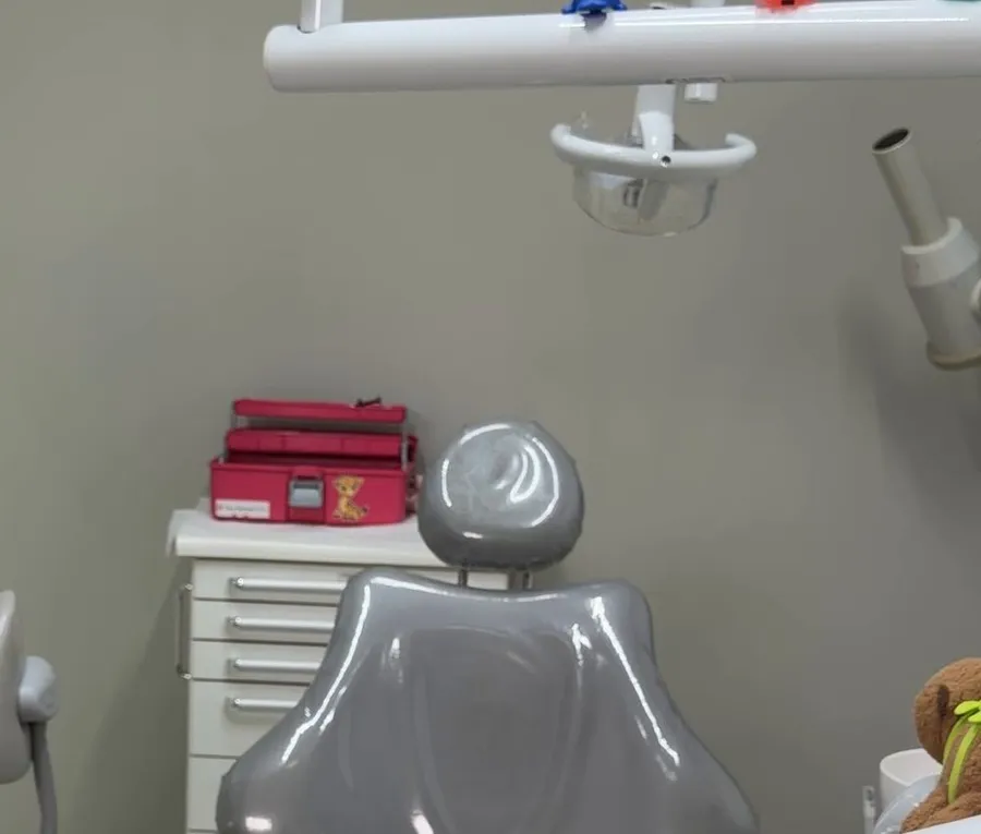 Consultório com a cadeira odontológica e brinquedos para o atendimento infantil